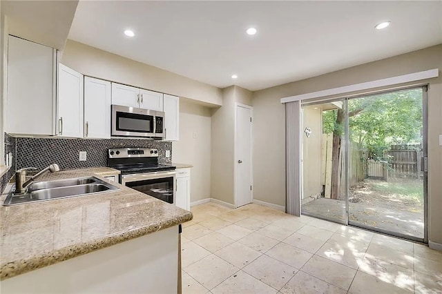 10400 Burmaster Ln Unit A, Austin, TX 78750 - kitchen with appliances with stainless steel finishes, a sink, tasteful backsplash, baseboards, and white cabinetry