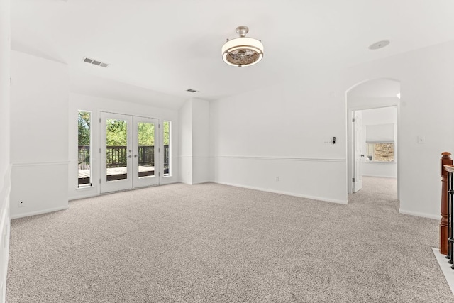 12501 Rush Creek Ln, Austin, TX 78732 - empty room with carpet floors, arched walkways, baseboards, and french doors