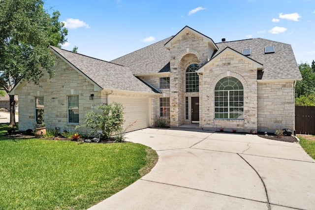 12501 Rush Creek Ln, Austin, TX 78732 - french country style house featuring stone siding, roof with shingles, an attached garage, and driveway