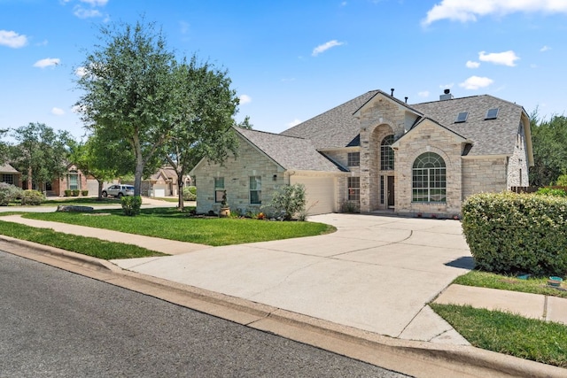12501 Rush Creek Ln, Austin, TX 78732 - french country home featuring stone siding, an attached garage, concrete driveway, and a front yard