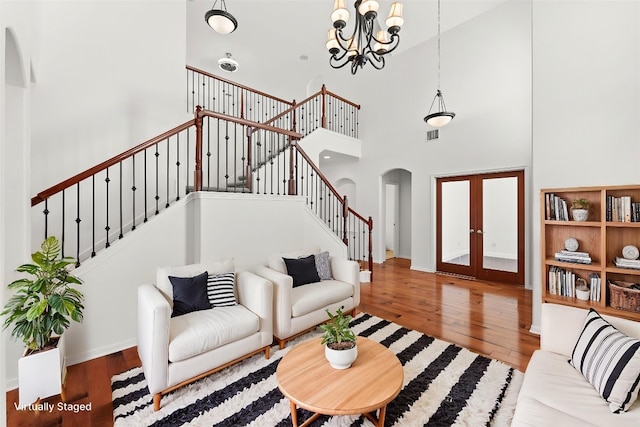 12501 Rush Creek Ln, Austin, TX 78732 - living area featuring arched walkways, a high ceiling, stairway, hardwood / wood-style floors, and a chandelier