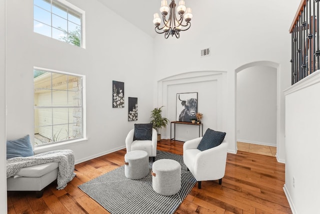 12501 Rush Creek Ln, Austin, TX 78732 - living area with a high ceiling, a chandelier, arched walkways, and hardwood / wood-style flooring