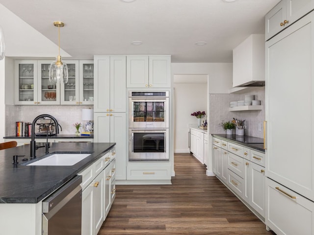 2300 Toulouse Dr, Austin, TX 78748 - kitchen featuring stainless steel appliances, a sink, dark wood-style floors, backsplash, and glass insert cabinets