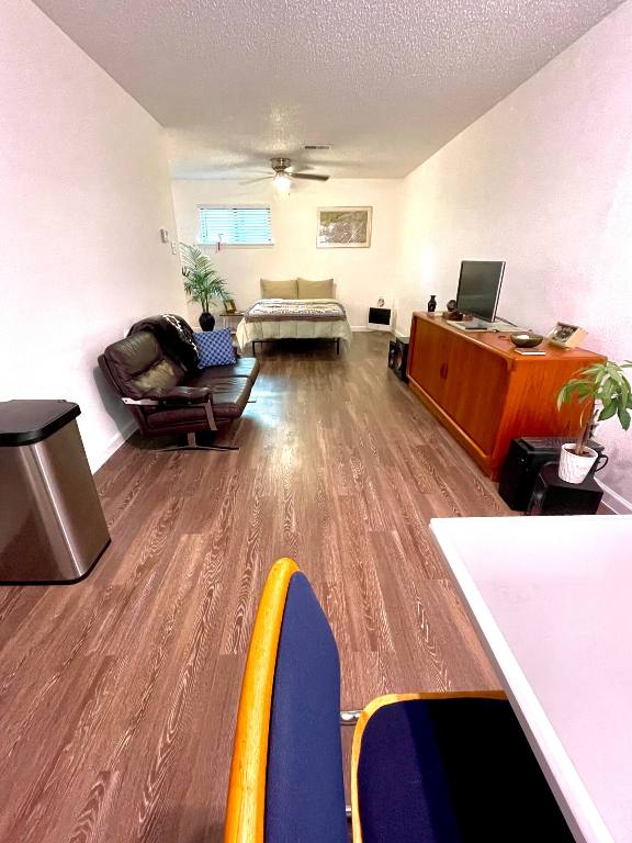 4701 Red River St Unit 104, Austin, TX 78751 - living area featuring wood finished floors, a ceiling fan, and a textured ceiling