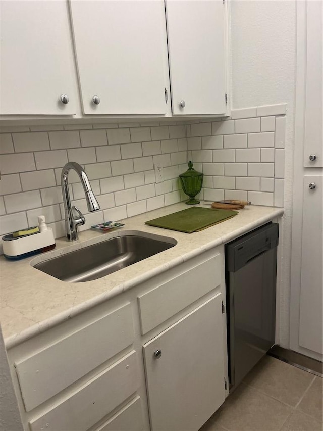 4701 Red River St Unit 104, Austin, TX 78751 - kitchen with stainless steel dishwasher, a sink, white cabinetry, tasteful backsplash, and light countertops