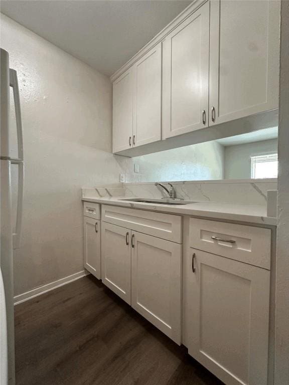 5207 Tahoe Trl Unit A, B, C, & D, Austin, TX 78745 - kitchen featuring a sink, dark wood-style flooring, freestanding refrigerator, white cabinetry, and baseboards