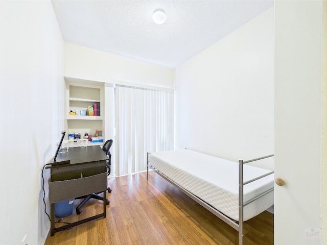 2905 Swisher St Unit 205, Austin, TX 78705 - bedroom with wood finished floors, a textured ceiling, and an office area