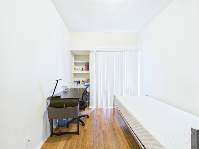 2905 Swisher St Unit 205, Austin, TX 78705 - bedroom featuring wood finished floors, a desk, and baseboards