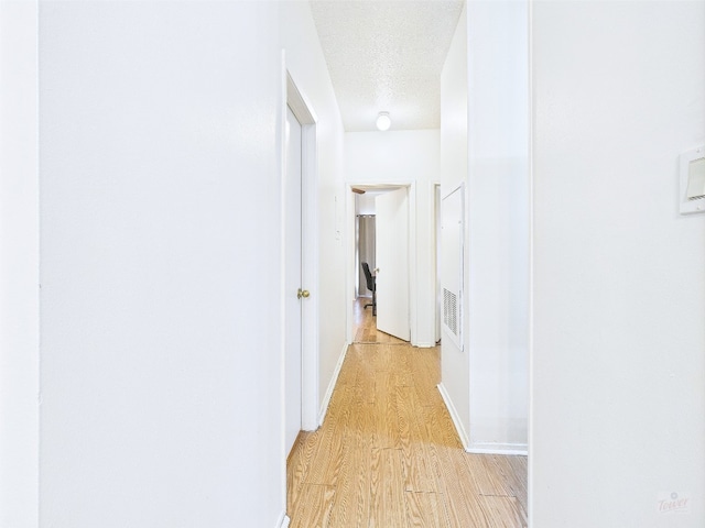 2905 Swisher St Unit 205, Austin, TX 78705 - hallway featuring light wood finished floors, a textured ceiling, and baseboards