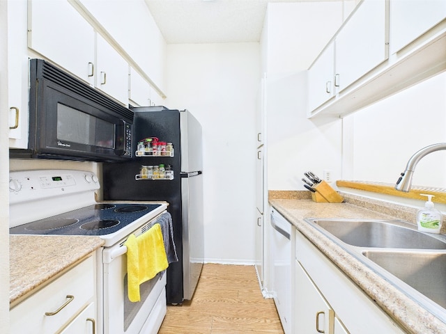 2905 Swisher St Unit 205, Austin, TX 78705 - kitchen with white appliances, a sink, white cabinets, light countertops, and light wood finished floors
