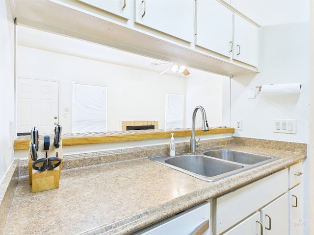 2905 Swisher St Unit 205, Austin, TX 78705 - kitchen with a sink, light countertops, white cabinets, a fireplace, and a ceiling fan