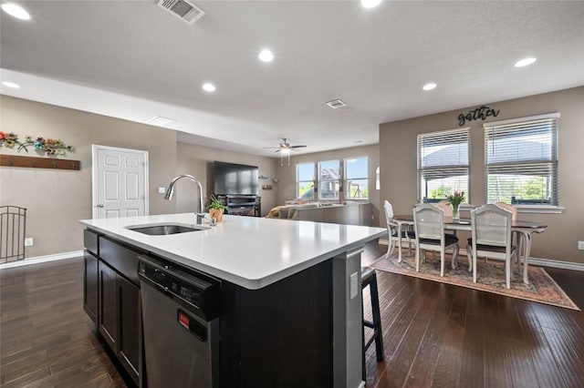 160 Thornless Cir, Buda, TX 78610 - kitchen featuring stainless steel dishwasher, a sink, baseboards, light countertops, and dark wood-style floors