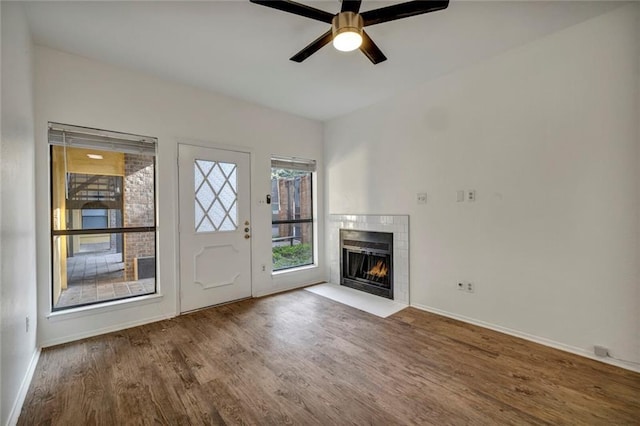 806 W 24th St Unit 114, Austin, TX 78705 - unfurnished living room with wood finished floors, ceiling fan, a tile fireplace, and baseboards