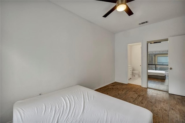 806 W 24th St Unit 114, Austin, TX 78705 - bedroom with wood finished floors, ensuite bathroom, ceiling fan, and baseboards