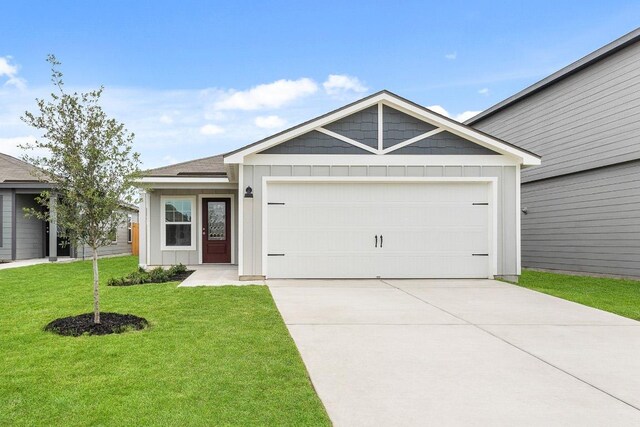 ranch-style house featuring board and batten siding, a garage, driveway, and a front lawn