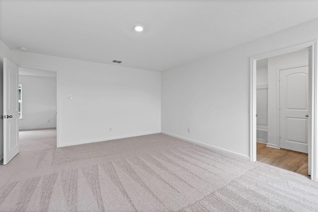 carpeted spare room featuring baseboards and a smoke detector