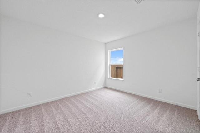 unfurnished room featuring light colored carpet and baseboards