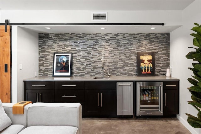 909 Electra, Lakeway, TX 78734 - indoor bar with beverage cooler, concrete flooring, decorative backsplash, recessed lighting, and a barn door