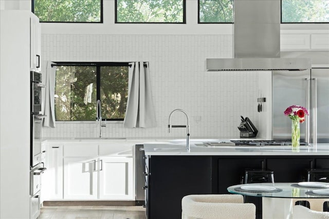 909 Electra, Lakeway, TX 78734 - kitchen with a sink, wall chimney exhaust hood, white cabinets, and backsplash