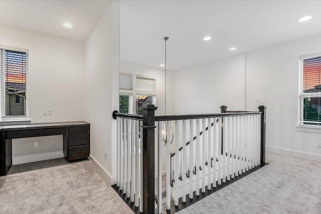 hall with an upstairs landing, carpet flooring, baseboards, and recessed lighting