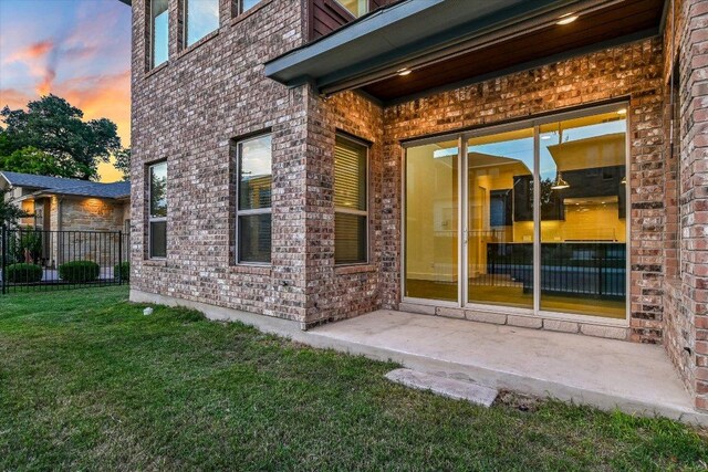 301 Jeffrey David Ln W, Austin, TX 78717 - exterior entry at dusk with brick siding and a patio
