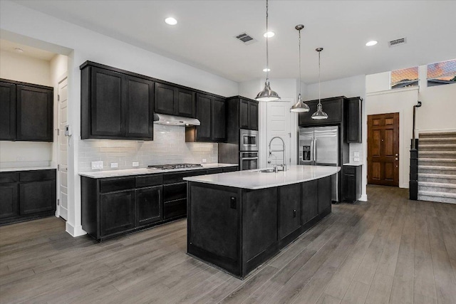 301 Jeffrey David Ln W, Austin, TX 78717 - kitchen with stainless steel appliances, dark cabinets, under cabinet range hood, light countertops, and recessed lighting