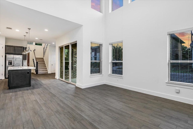 301 Jeffrey David Ln W, Austin, TX 78717 - unfurnished living room with dark wood-type flooring, stairway, plenty of natural light, and recessed lighting