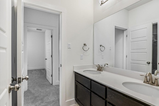 bathroom with double vanity and baseboards
