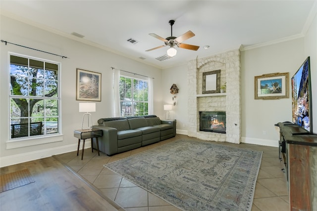 108 Tumbleweed Trl, Austin, TX 78733 - tiled living area with a stone fireplace, a ceiling fan, crown molding, and baseboards