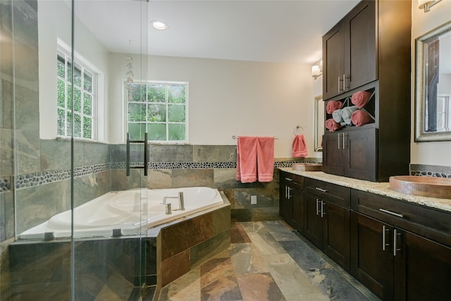 108 Tumbleweed Trl, Austin, TX 78733 - full bathroom featuring stone tile flooring, vanity, a garden tub, and an enclosed shower
