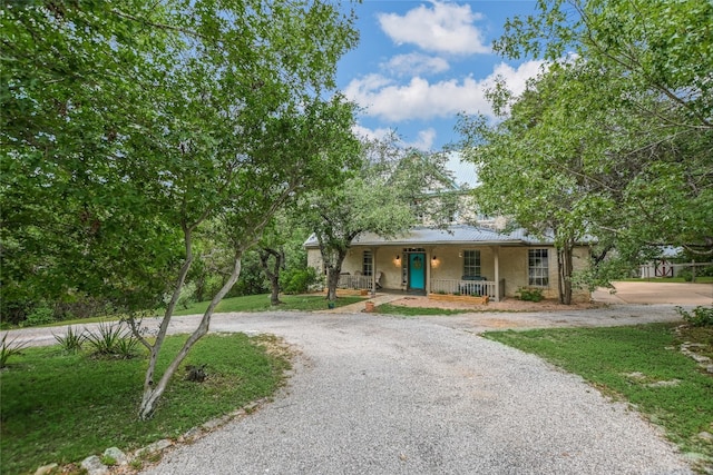 108 Tumbleweed Trl, Austin, TX 78733 - view of front of home featuring a porch, curved driveway, and metal roof