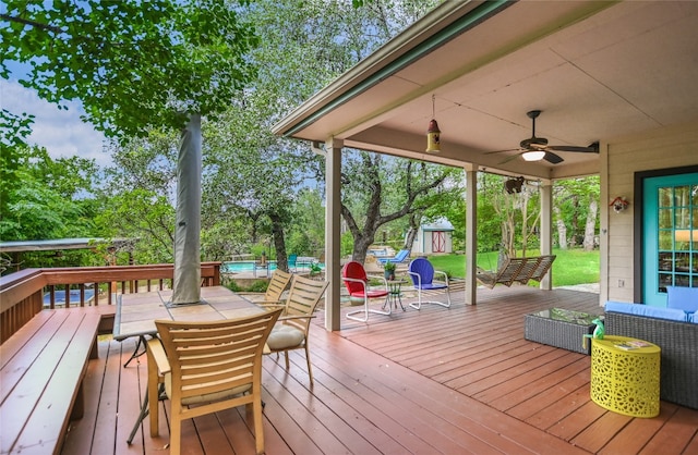 108 Tumbleweed Trl, Austin, TX 78733 - deck with outdoor dining space, a ceiling fan, an outdoor pool, and view of scattered trees