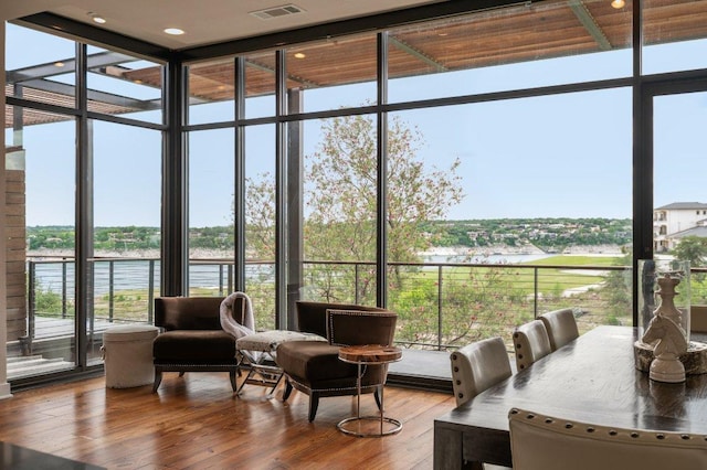 sunroom featuring a water view