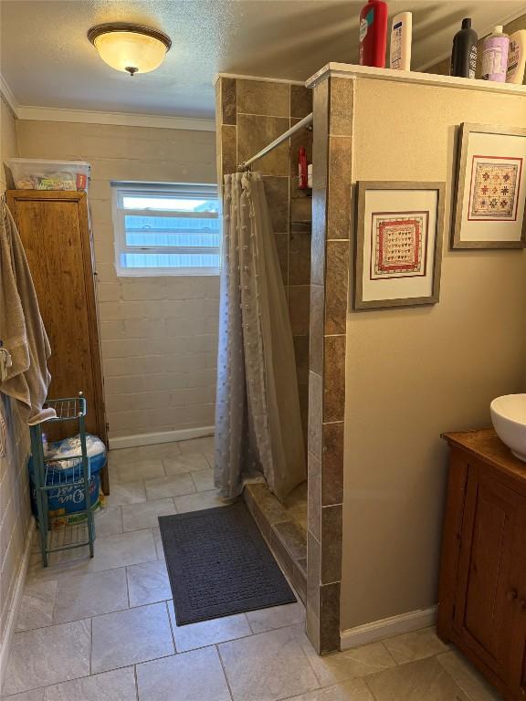 full bathroom featuring a stall shower, ornamental molding, and baseboards