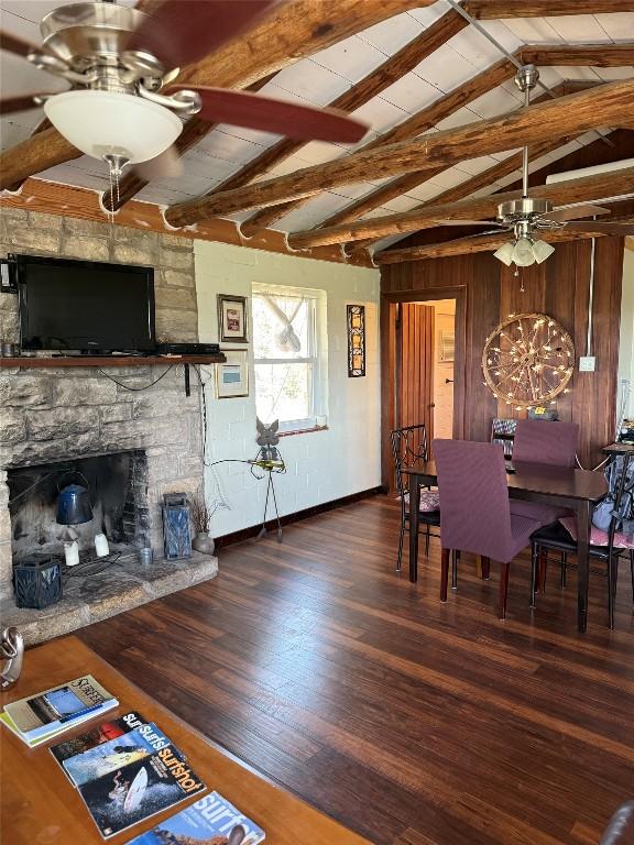 living area with a ceiling fan, a fireplace, wood finished floors, baseboards, and wood walls