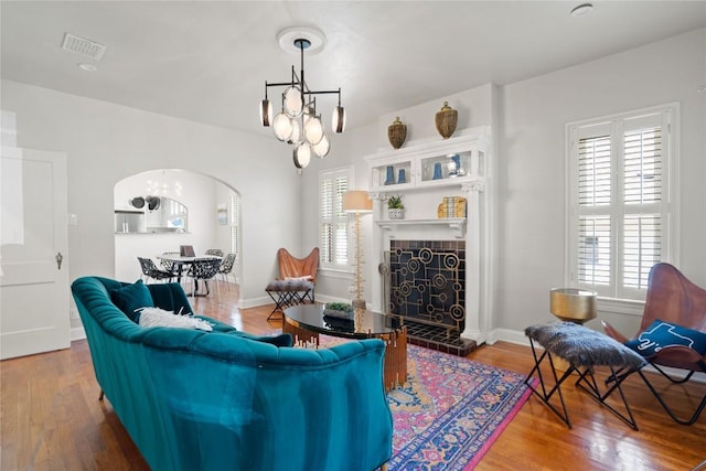2106 Kenwood Ave, Austin, TX 78704 - living area featuring a chandelier, wood finished floors, a fireplace, and arched walkways