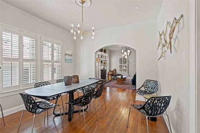 2106 Kenwood Ave, Austin, TX 78704 - dining area with a chandelier, arched walkways, and hardwood / wood-style floors