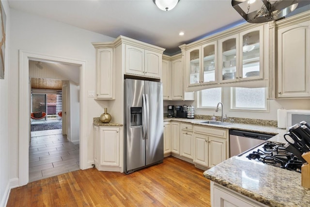 2106 Kenwood Ave, Austin, TX 78704 - kitchen featuring appliances with stainless steel finishes, a sink, cream cabinets, and recessed lighting