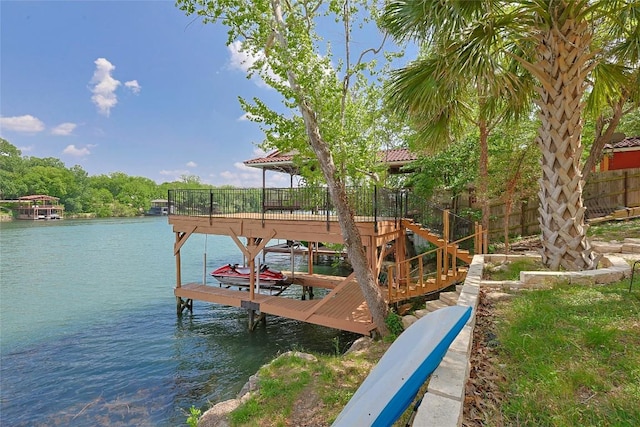 dock area with boat lift, a water view, and fence