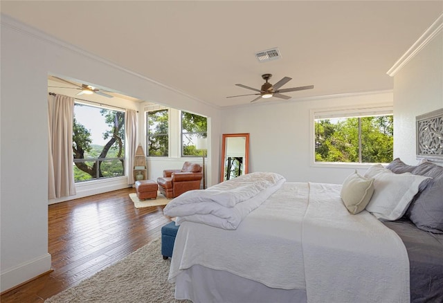 bedroom featuring crown molding, hardwood / wood-style floors, baseboards, and ceiling fan