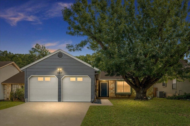 single story home with stone siding, driveway, cooling unit, a lawn, and an attached garage