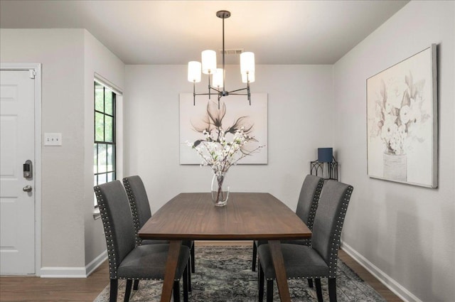 dining area featuring a chandelier, wood finished floors, and baseboards