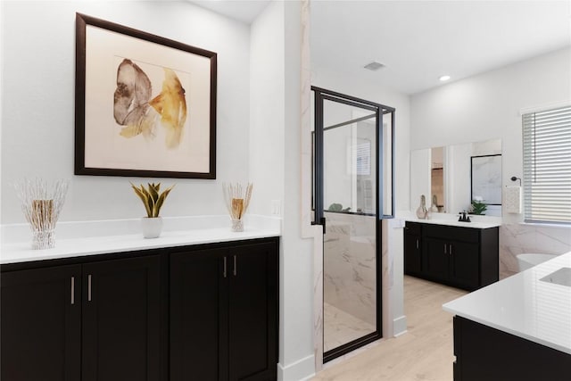 232 San Xavier St, Georgetown, TX 78633 - bathroom with a marble finish shower, vanity, and wood finished floors