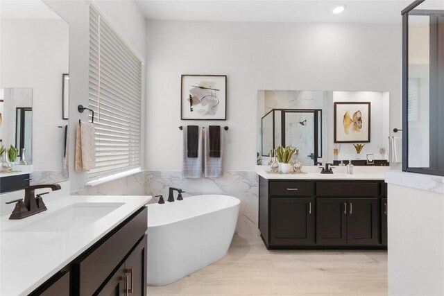 232 San Xavier St, Georgetown, TX 78633 - bathroom featuring a shower stall, tile walls, a soaking tub, wainscoting, and two vanities