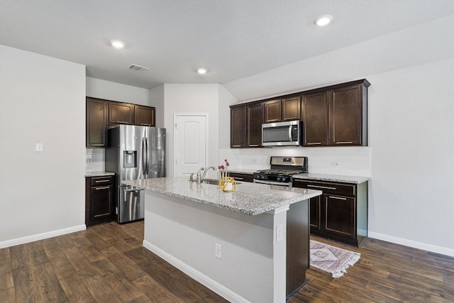 13921 Allan Shivers St, Manor, TX 78653 - kitchen featuring appliances with stainless steel finishes, dark brown cabinets, dark wood finished floors, backsplash, and recessed lighting