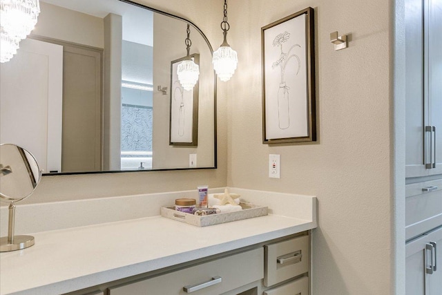 bathroom featuring vanity, a textured wall, and a chandelier