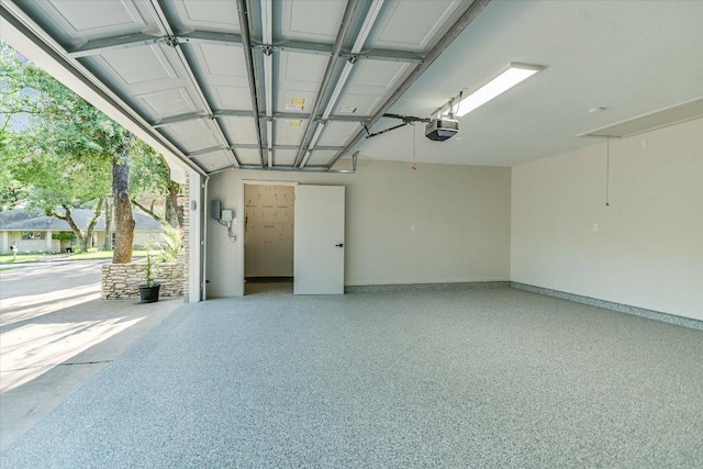 garage with a garage door opener and baseboards