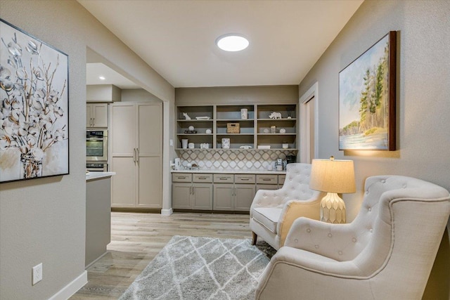 living area featuring light wood-style flooring and baseboards