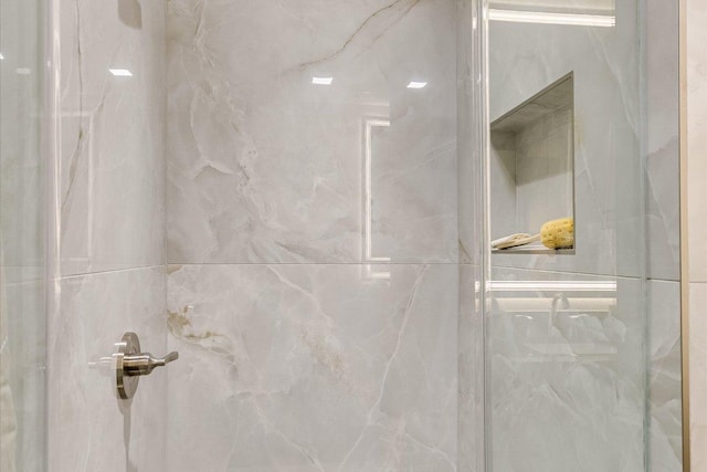 bathroom view of a marble finish shower
