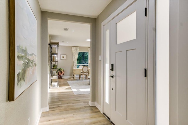 foyer featuring light wood-style floors, baseboards, and recessed lighting